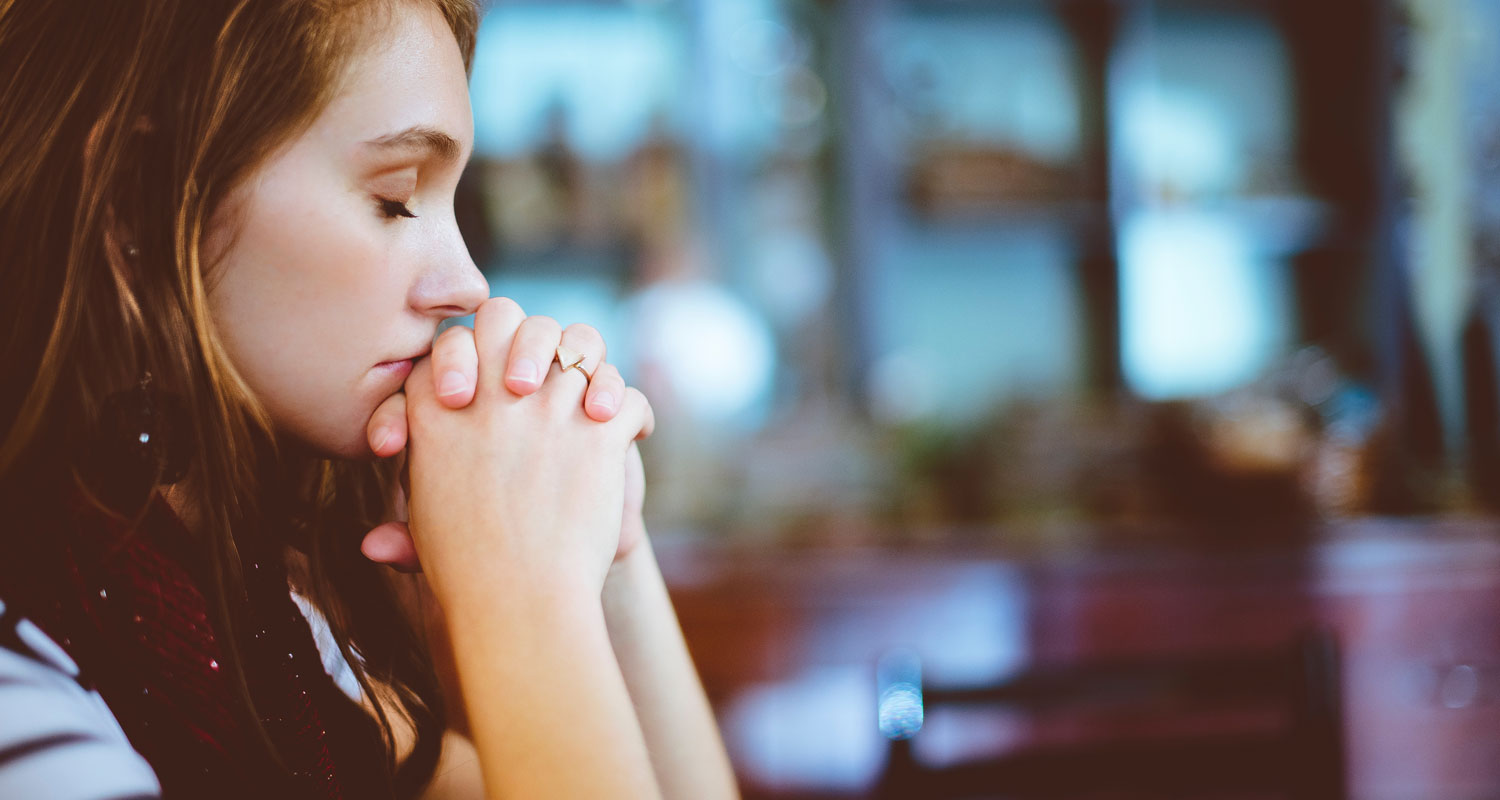 Woman praying at table